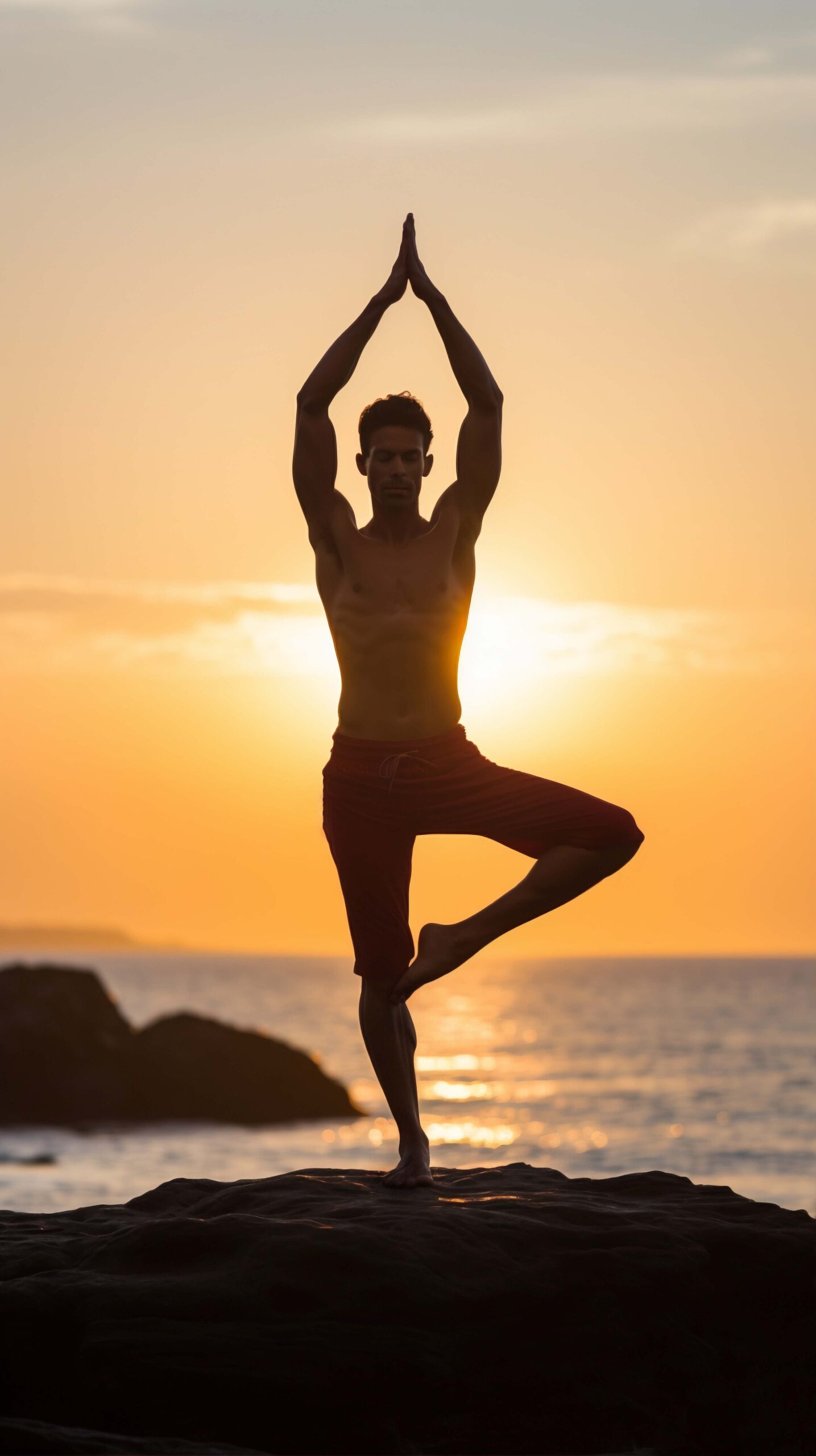 Healthy lifestyle and wellness concept with man meditating by the ocean at sunset.